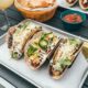three fresh tacos on gray tray
